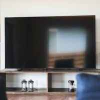 The living room TV is 75 inches. On a wall on each bedroom